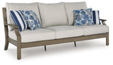 J&M Furniture - Ashley Furniture - Rainier Ranch Outdoor Sofa with Cushion - Sofa with Cushion / Brown/Beige - P701-838