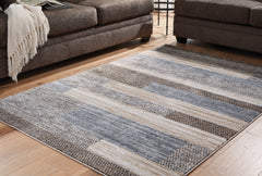 J&M Furniture - Ashley Furniture - Sethburn 5' x 7' Rug - 5' x 7' Rug / Cream/Brown/Gray - R406592